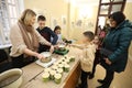 A volunteers teach children how to make trench candles for military during the event \'Warm for dad