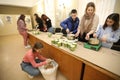 A volunteers teach children how to make trench candles for military during the event \'Warm for dad