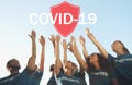 Volunteers uniting to help during COVID-19 outbreak. Group of people raising hands, shield illustration