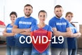 Volunteers uniting to help during COVID-19. Group of people and shield illustration