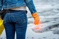 Volunteers wear jeans and long sleeved shirts and wear orange rubber gloves to collect garbage on the beach. Beach environment. Royalty Free Stock Photo