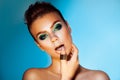 Voluptuous adult woman with green colors makeup on blue backgrou Royalty Free Stock Photo