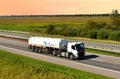 Volvo heavy fuel tanker truck by `GAZPROM` driving on highway on sunset background. Out of focus, possible granularity, motion Royalty Free Stock Photo