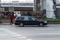 Volvo V40 estate car driving on a city road. Side view of old car speeding along industrial district