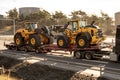 Volvo wheel loaders being transported on a trailer..