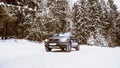 Volvo XC90 SUV stands in the snow covered forest during winter day Royalty Free Stock Photo