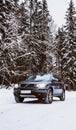 Volvo XC90 SUV stands in the snow covered forest during winter day