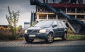 Volvo XC90 SUV stands on the street against the background of an abandoned industrial building with stairs and open areas on an au Royalty Free Stock Photo