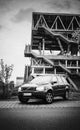 Volvo XC90 SUV stands on the street against the background of an abandoned industrial building with stairs and open areas on an au