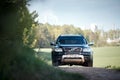 Volvo XC90 4.4 v8 1st generation restyling 4WD SUV test drive in spring field country road on forest background with tubes and