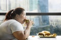 Voracious fat woman eating burger in the restaurant Royalty Free Stock Photo