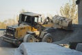 Voronezh region, Russia, april, 25 2019. Tractor loads crushed stone in the production of concrete. Yellow tractor loader running