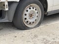 Voronezh, Russia April 2, 2021: Car with deflated wheel on street. Old gray car with deflated wheel parked on paved