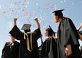 Voronezh, Russia - July 1, 2016: University graduates in black mantles rejoice against the sky and balloons