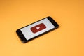 VORONEZH. Russia - may 03, 2019: Brand new Apple iPhone 7 with logo YouTube, on an orange background. YouTube is the popular