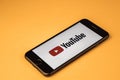 VORONEZH. Russia - may 03, 2019: Brand new Apple iPhone 7 with logo YouTube, on an orange background. YouTube is the popular