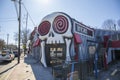 The Vortex Bar and Grill with a skull over the top of the door,, bare winter trees, cars and trucks driving on the street