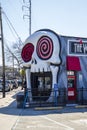 The Vortex Bar and Grill with a skull over the top of the door,, bare winter trees, cars and trucks driving on the street