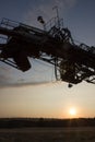 Fragment of a multi-bucket excavator giant against the light against the sunset