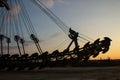 Fragment of a multi-bucket excavator giant against the light against the sunset