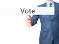 Vote - Businessman hand holding sign