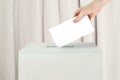 Vote concept. Voter hand holding ballot paper for election vote on polling station