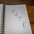 Vote, handwriting text on paper, political message. Political text on office agenda. Concept of democracy, voting, politics. Copy