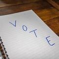 Vote, handwriting text on paper, political message. Political text on office agenda. Concept of democracy, voting, politics. Copy