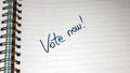 Vote now, handwriting  text on paper, political message. Political text on office agenda. Concept of democracy, voting, politics. Royalty Free Stock Photo