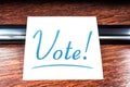 Vote Sticky Note On Paper Lying On Wooden Cupboard