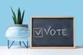 Vote Written On Blackboard. The concept of making choices with medical mask. Presidential and parliamentary elections. Calling for Royalty Free Stock Photo