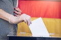 Voting on elections during pandemic. A woman& x27;s hand in gloveputs her vote into the ballot box. Royalty Free Stock Photo