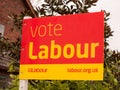 A voting sign outside red and yellow political