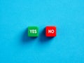 Voting yes or no. Positive or negative decision. To accept or reject. The opposite words yes or no on colorful cubes on blue