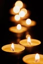 Votive candles burning in the darkness