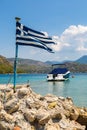 Vouliagmeni lake and greek flag, Greece