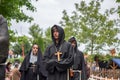 View of actor dressed in medieval clothes on medieval market, catholic friar dress, blurred background