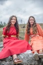 View of two actress girls dressed in medieval clothes on medieval market, blurred background