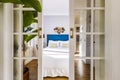 Voyeur view of a decorated bedroom through sliding wooden doors and mirror