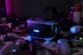 Close up of a vr headset with controllers on a cluttered desk under neon lighting in a dark room Royalty Free Stock Photo