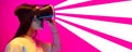 VR-headset. Caucasian woman& x27;s portrait isolated on pink studio background in mixed neon light. White and magenta Royalty Free Stock Photo