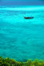 VThe sea looks out to emerald blue. There is 1 floating boat quietly on the waves in the Andaman Sea. At Sunset Beach, Koh Lipe, S Royalty Free Stock Photo