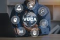 VUCA - Volatility,Uncertainty,Complexity,Ambiguity.Businessman holding world icon and VUCA icon.