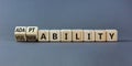 Vulnerability or adaptability symbol. Turned wooden cubes and changed words `vulnerability` to `adaptability`. Grey background