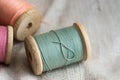 Vintage wooden thread spools on linen cloth, pastel colors, closeup, styled image Royalty Free Stock Photo