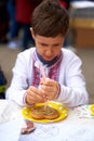 Vyshyvanka day in Ukraine. Kid painting Ukrainian flag in shape of heart on gingerbread