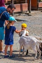 Vyskov, Czech Republic - 4.7.2021: Parents and kids are touching and feeding the goats at small farm Royalty Free Stock Photo