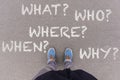 5W questions on asphalt ground, feet and shoes on floor Royalty Free Stock Photo