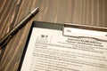 W-7 tax form with pen on wooden desk