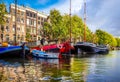 Waalseiland Canal with its historic canal houses, houseboats and commercial river boats in the old city center of Amsterdam Royalty Free Stock Photo